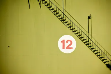 A photo by Michael Skok of of a staircase passing a large number 12