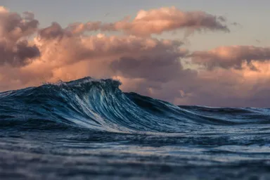 A photo by Silas Baisch of a wave against a dark and moody sky.